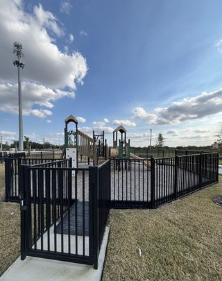 Community Amenities A fenced playground with slides and climbing structures, perfect for families, in Emerald Pointe by Pulte Homes (Apopka, FL).