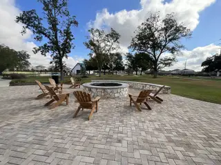 A cozy fire pit area with Adirondack chairs, offering a warm and inviting space for relaxation.