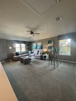 A cozy living room featuring a spacious sectional sofa, modern decor, and ample natural light from large windows.
