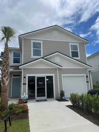 A modern two-story home with clean lines and a manicured lawn in Irongate Villas by D.R. Horton (Jacksonville, FL).