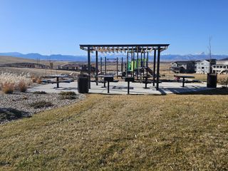A scenic park with a modern pergola and mountain views in Sunset Village: Paired Homes by Lennar (Erie, CO).