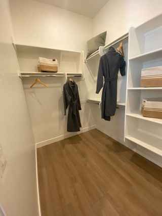 A well-organized walk-in closet features built-in shelving, hanging rods, and wood-look laminate flooring, offering ample storage space.