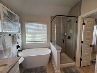 Model Home A chic bathroom featuring a sleek freestanding tub, glass-enclosed shower, and elegant decor.