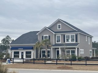 Street view A charming gray two-story home with palm trees in Waterside at Lakes of Cane Bay: Arbor Collection by Lennar (Summerville, SC).