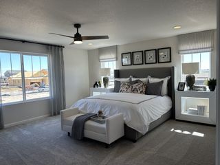 Model Home A spacious bedroom with modern decor, plush carpeting, and large windows offering abundant natural light.