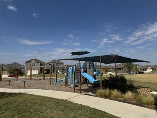 Community Amenities A charming playground with slides in a scenic neighborhood at Firefly Pointe: Stonehill Collection by Lennar (Hutto, TX).