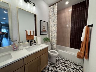 A modern bathroom with a dual-sink vanity, patterned floor tiles, and sleek lighting for a contemporary feel.