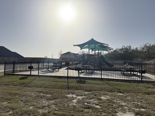 A vibrant community playground in Ladera by Coventry Homes, located in San Antonio, TX. This inviting space offers fun for all.