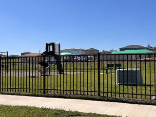 A delightful playground in Phillips Landing by Starlight Homes, featuring lush grass and a charming play structure (Groveland, FL).