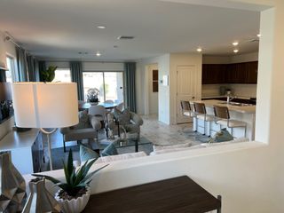 A modern open-concept living area featuring a cozy seating nook, sleek kitchen, and elegant dining space.