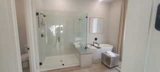Model Home A modern bathroom with a glass shower, freestanding tub, and elegant accents.