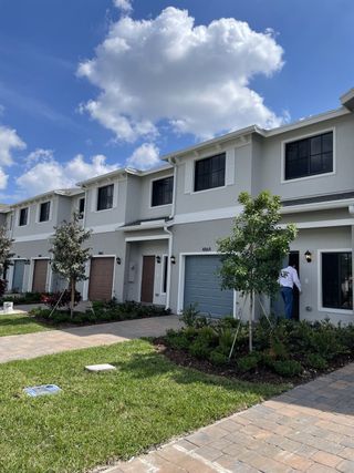 Modern townhomes with sleek design and lush landscaping in Ashwood Cove by D.R. Horton (Lake Worth, FL).