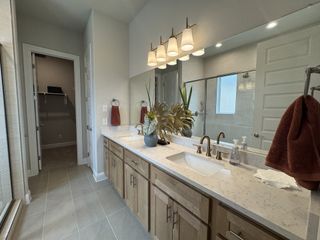 Luxurious bathroom with a double vanity, modern fixtures, a large mirror, and a walk-in shower.