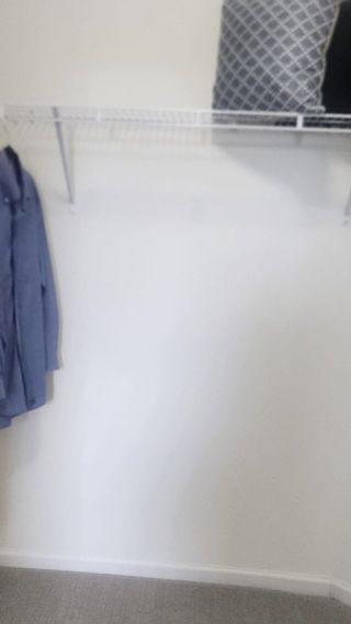 A spacious walk-in closet with carpet flooring and ample shelving for organized storage.