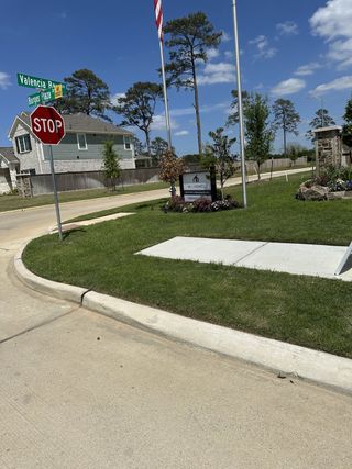Street view A serene neighborhood view in the Sorella community by M/I Homes, featuring lush greenery and a welcoming corner in Tomball, TX.