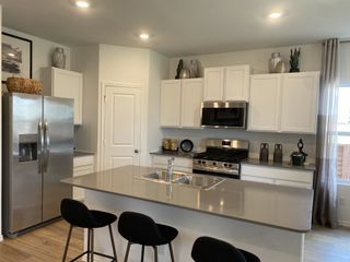 A modern kitchen featuring sleek stainless steel appliances, white cabinetry, and ample counter space with elegant decor.