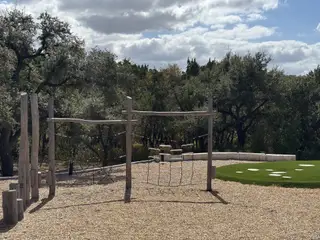 Community Amenities A rustic playground with climbing structures in Wolf Ranch - 60' by Drees Custom Homes (Georgetown, TX).