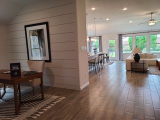 An open-concept living area with elegant tile flooring, stylish dining space, and cozy seating. Abundant natural light throughout.