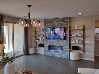 A modern living room featuring a sleek stone fireplace, built-in shelves, and elegant lighting.