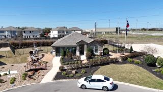 A charming brick home with manicured landscaping and a playground in Steele Creek by D.R. Horton (Cibolo, TX).