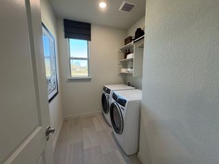 A modern laundry room with natural light, sleek shelves, and a side-by-side washer-dryer for optimal functionality.
