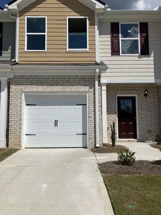 A charming townhouse with a single-car garage and neutral exterior in Lakeview Commons by Sunrise Builders, Inc (Jonesboro, GA).
