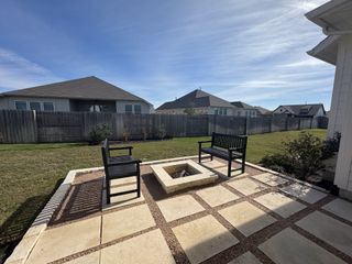 Model Home A cozy backyard patio with a fire pit and seating, perfect for relaxing afternoons.