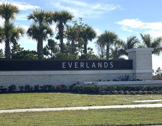 A welcoming entrance with palm trees at Riverwood at Everlands: The Shoals Collection by Lennar in Palm Bay, FL.