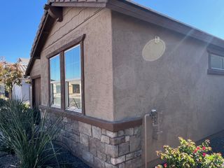 A charming stone-accented home with landscaped surroundings in McClellan Ranch by Pulte Homes (Laveen, AZ).