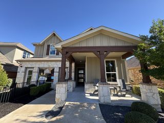 A charming stone and wood home with a welcoming porch in Sunfield by Pulte Homes (Buda, TX).