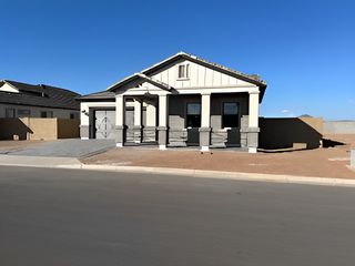 A modern single-story home with a stone-accented entrance in Grove at Lehi by Blandford Homes (Mesa, AZ).