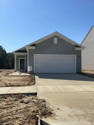 A charming grey home with a spacious garage in Pender Woods at Cane Bay by Starlight Homes (Summerville, SC).