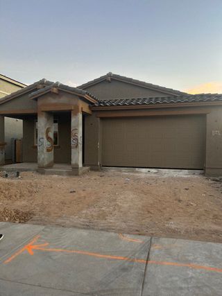 Street view A contemporary home with a covered entry and spacious garage in Allen Ranches: Fiesta Collection by Taylor Morrison (Litchfield Park, AZ).