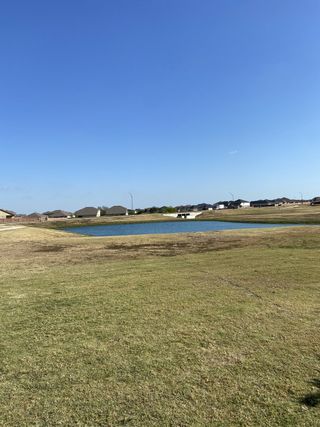 A peaceful pond surrounded by lush green space, offering scenic views in Saddle Creek Twinhomes by Pacesetter Homes (Georgetown, TX).