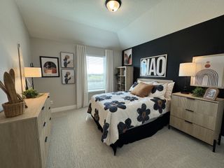 A cozy bedroom with a bold accent wall, floral bedding, and modern artwork, creating a stylish and inviting atmosphere.