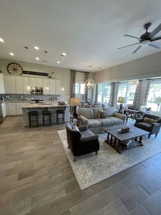A spacious living area with a cozy sofa, elegant lighting, and large windows, perfect for entertaining and relaxation.
