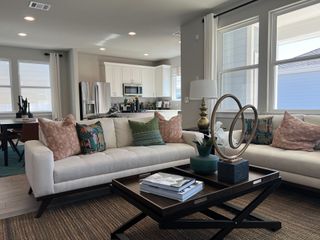 Model Home A cozy living space with chic decor, a contemporary coffee table, and an open kitchen.