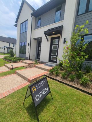 A modern home with sleek design and a landscaped yard in Viridian by Cadence Homes (Arlington, TX).