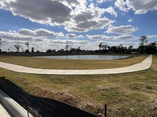 A scenic pond with a surrounding walkway in Cypresswood Point by Long Lake Ltd. (Humble, TX).