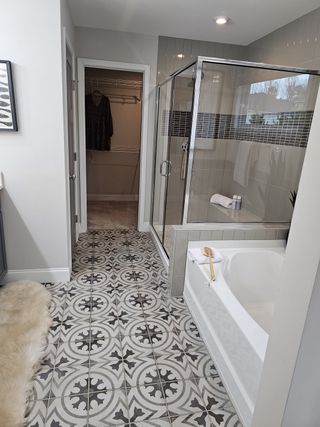 A spa-like bathroom featuring patterned tile floors, a glass-enclosed shower, and a soaking tub for ultimate relaxation.