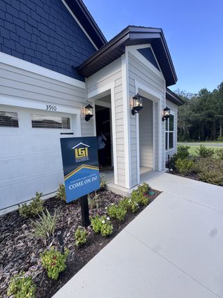 A charming modern home with blue accents and inviting porch in Jennings Farm by LGI Homes (Middleburg, FL).