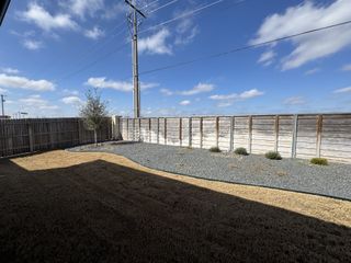 Model Home A spacious backyard with a wooden fence and minimal landscaping in Weltner Farms 50's by View Homes (New Braunfels, TX).