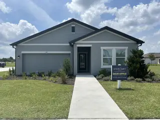 Street view A modern gray facade with manicured landscaping in Belair Place by Starlight Homes (Sanford, FL).