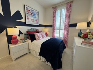 A vibrant bedroom featuring bold patterns, pink accents, and a creative wall design. 

