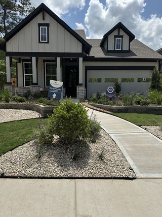 A charming home with elegant stone accents and lush landscaping in Colton 65' Homesites by David Weekley Homes (Todd Mission, TX).
