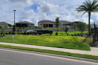 Beautiful homes with manicured lawns and a serene street view in Ridgeview by Trinity Family Builders (Clermont, FL).