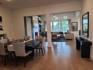 An elegant open-concept living and dining area with sleek furnishings and natural light streaming through large windows.