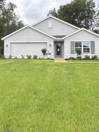 A modern gray home with shutters and a well-maintained lawn in Marion County Spot Lots by D.R. Horton (Ocala, FL).