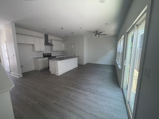 Model Home Spacious living area with light grey flooring, neutral tones, and a comfortable layout.