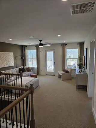 Model Home A cozy living area with plush seating, neutral tones, and ample natural light from multiple windows.